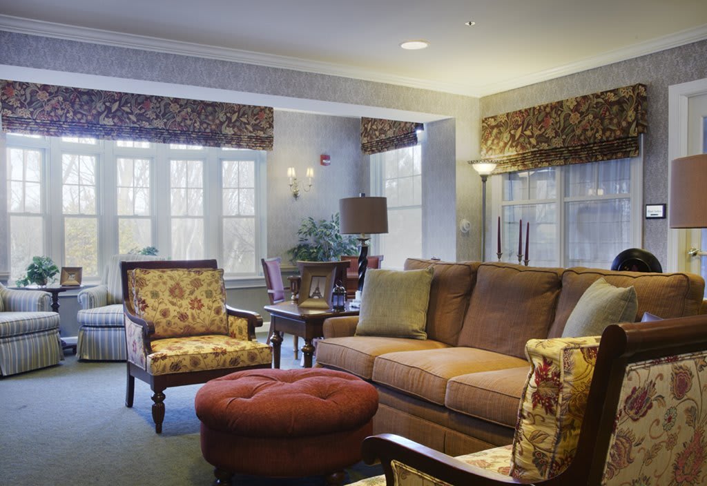 A cozy living room featuring a comfortable sofa, an armchair, and an ottoman with elegant decor.