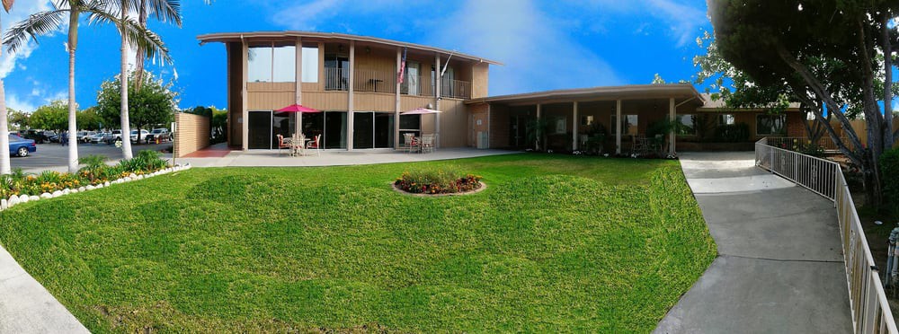A modern house with a well-maintained lawn under a clear blue sky.