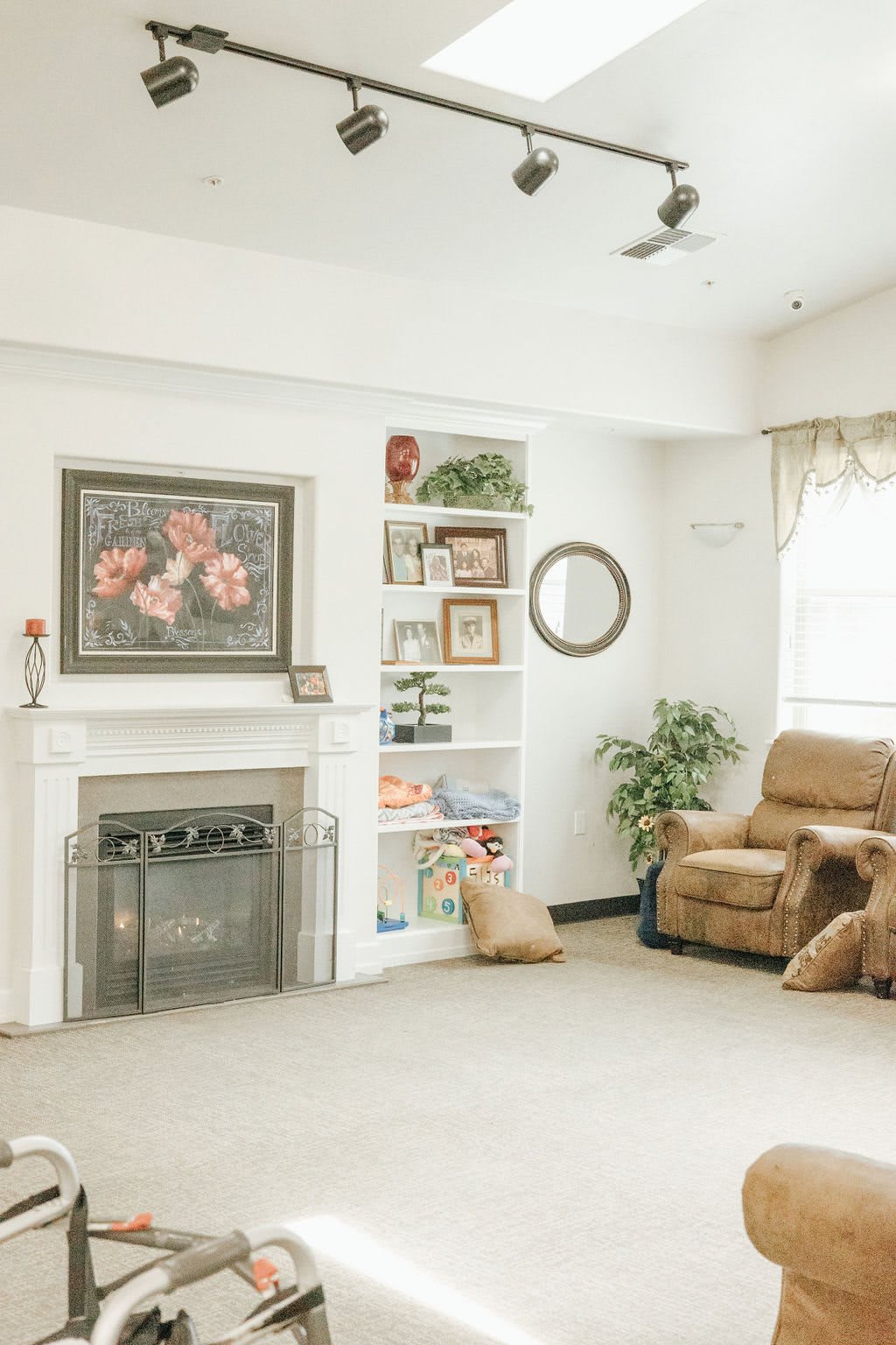 A cozy living room featuring a fireplace, bookshelf, and comfortable armchair.
