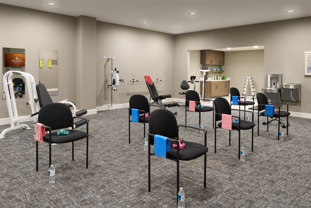 A modern rehabilitation clinic setup with chairs and exercise equipment.
