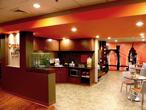 A modern and colorful lounge area featuring a kitchen space designed for hospitality.