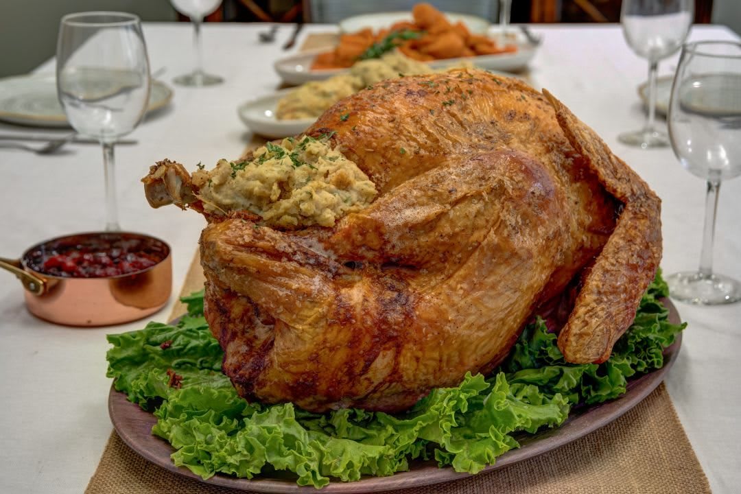 A deliciously roasted turkey with stuffing, served on a bed of lettuce, perfect for a holiday feast.