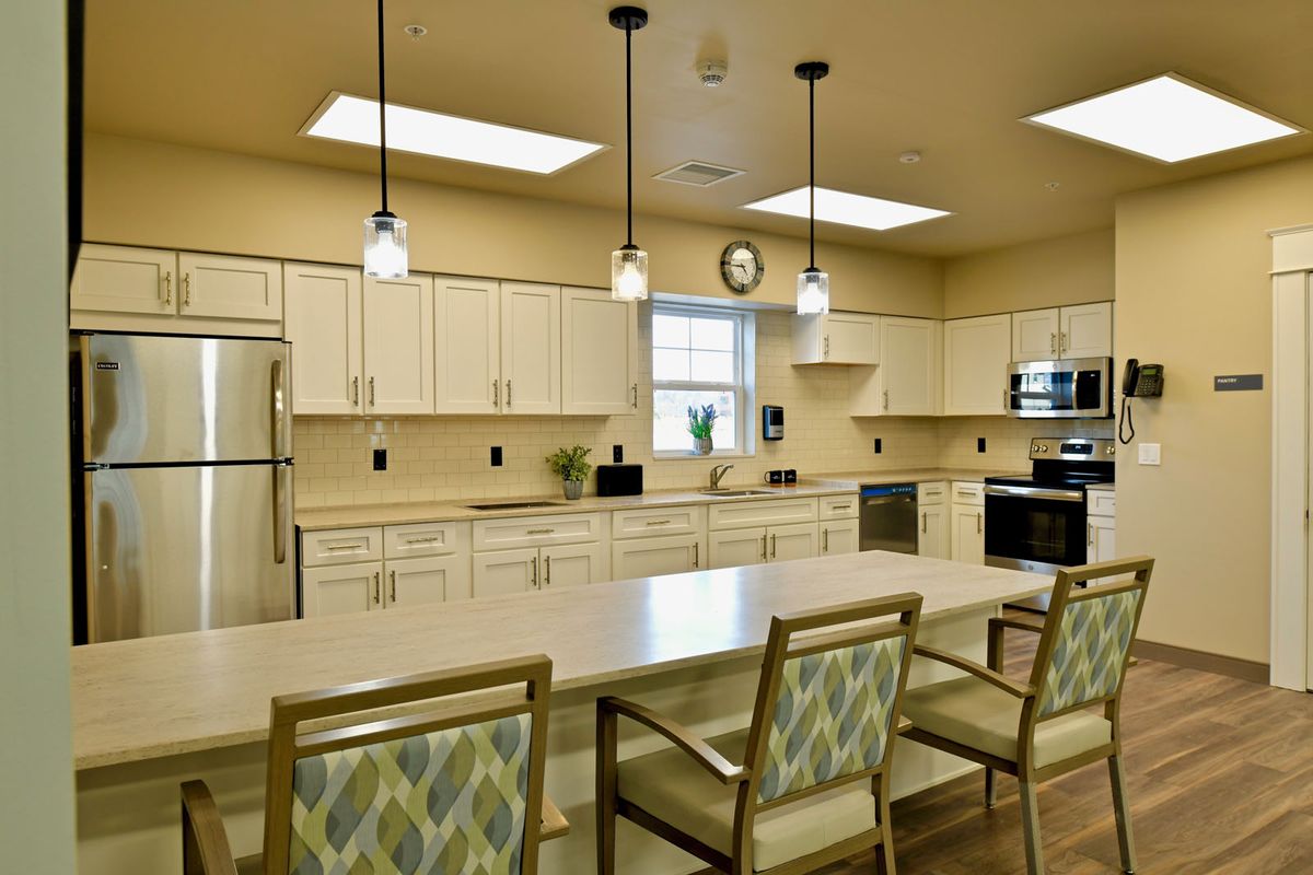 A spacious modern kitchen with a large island, overhead lighting, and contemporary appliances.