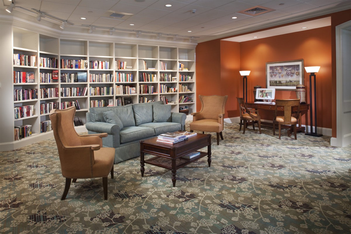 A cozy library space with comfortable seating and bookshelves lining the walls.