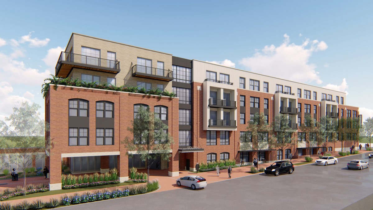 A modern apartment building with multiple balconies and landscaped surroundings.