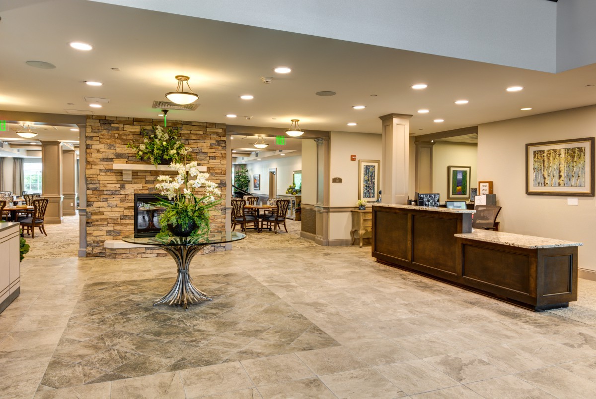 A spacious, well-lit hotel lobby with a reception desk and seating area.