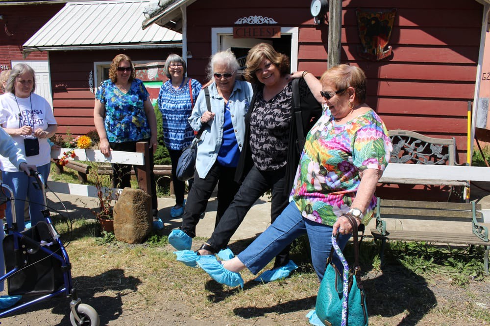 A group of women enjoying a fun moment outdoors, with some wearing protective shoe covers.