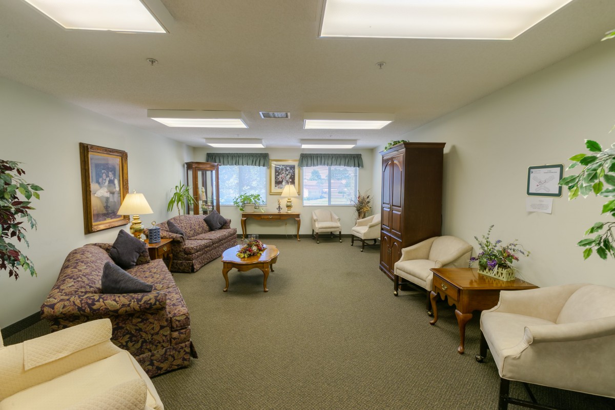 A cozy living room with sofas, armchairs, and a coffee table arranged around the space.
