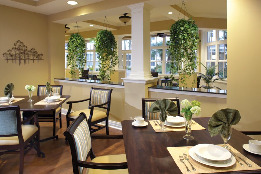 A beautifully decorated dining area with elegant table settings and lush greenery.