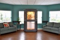 A cozy waiting room with an elevator, chairs, and ambient lighting.