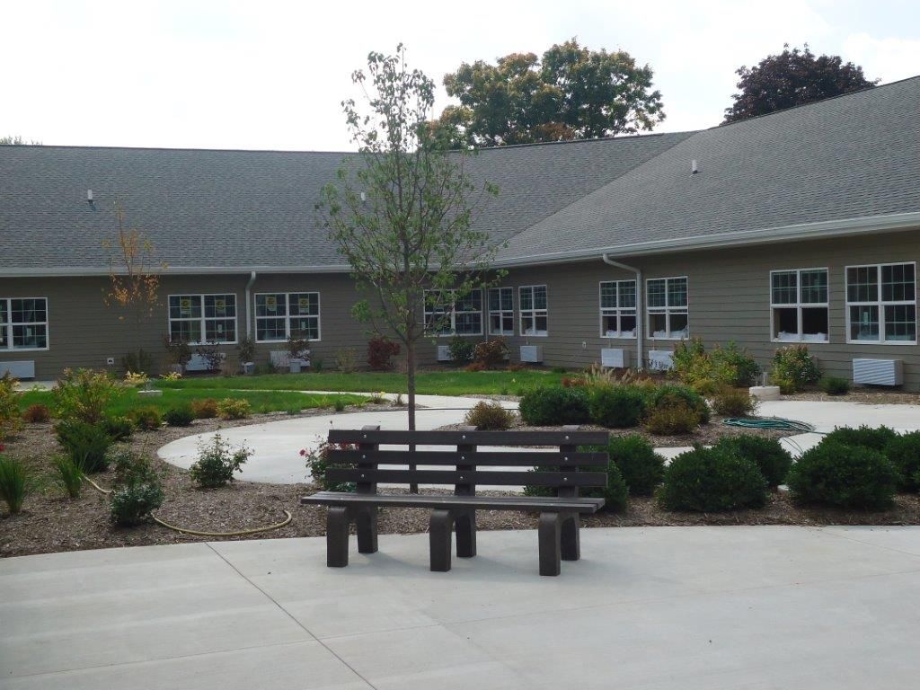 A peaceful courtyard with benches and landscaping in front of a building.