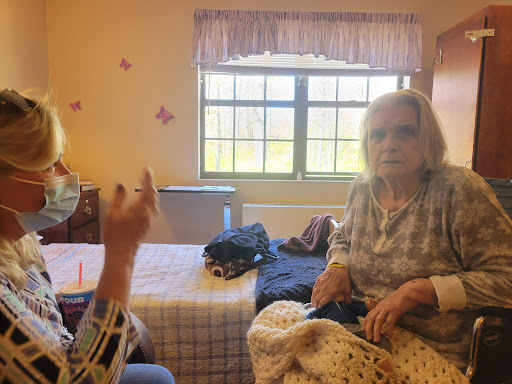 Two seniors engaged in a conversation in a cozy room.