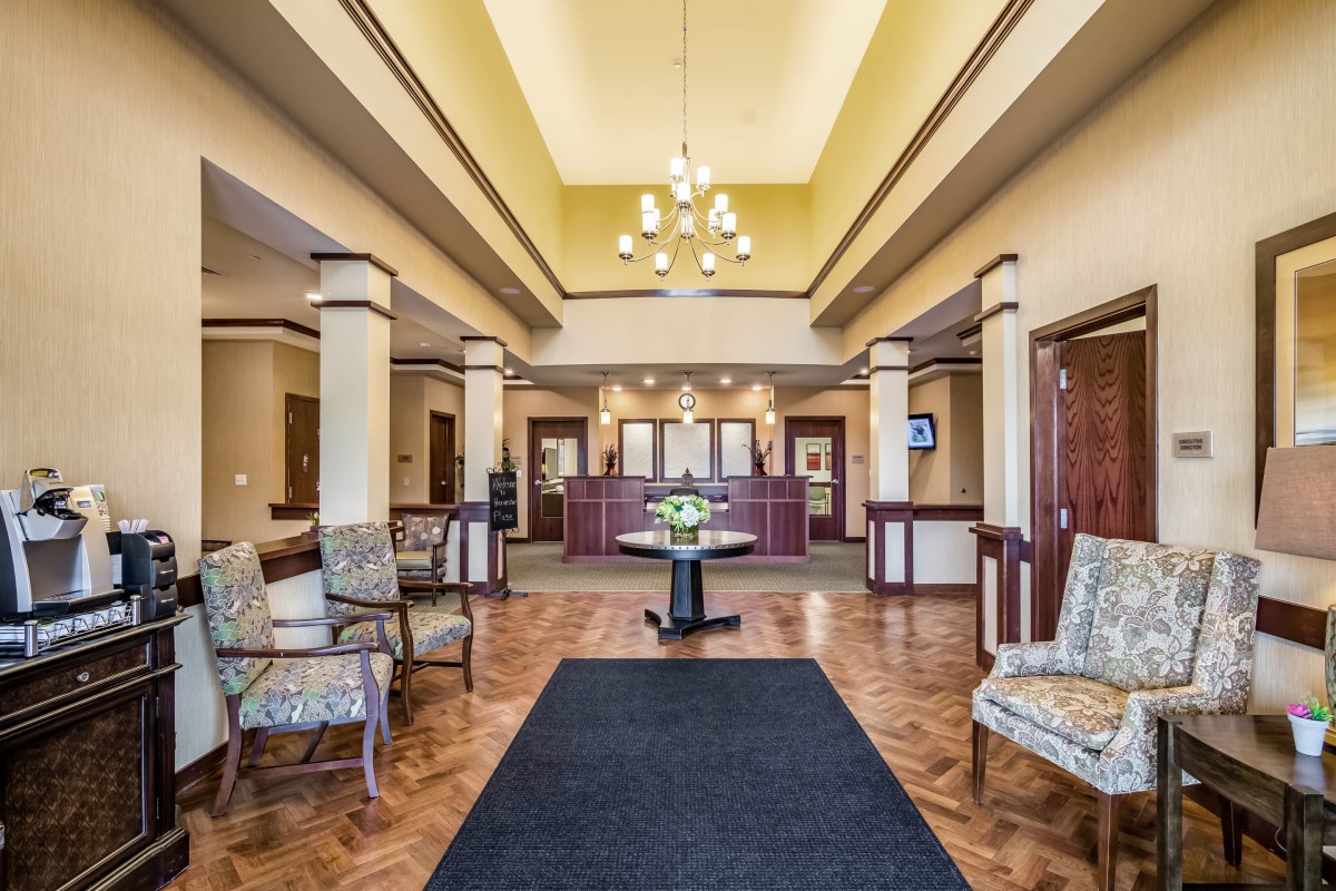 A spacious hotel lobby with elegant interior design, featuring a reception desk and comfortable seating.
