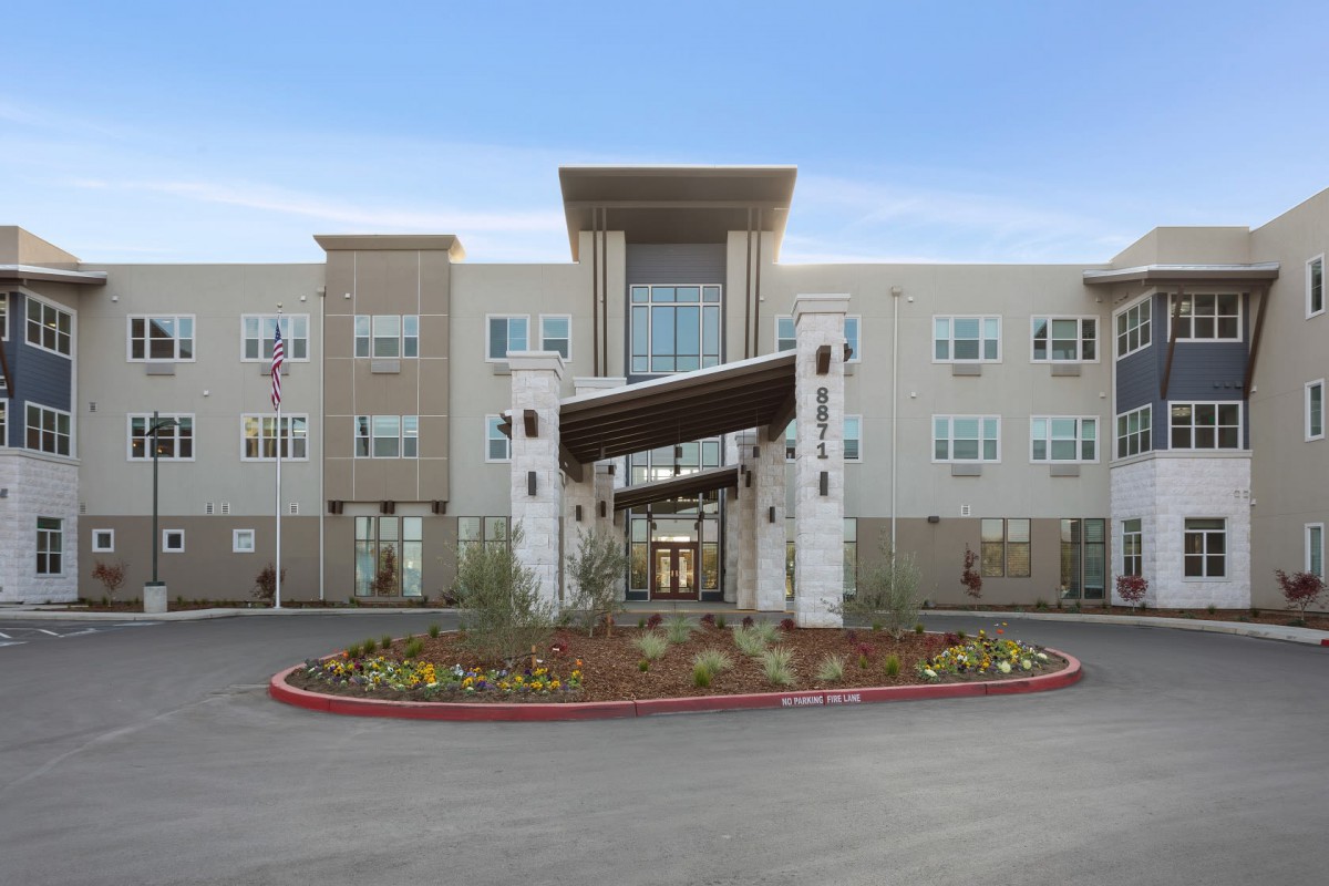 A modern building with a landscaped entrance and a distinctive architectural design.