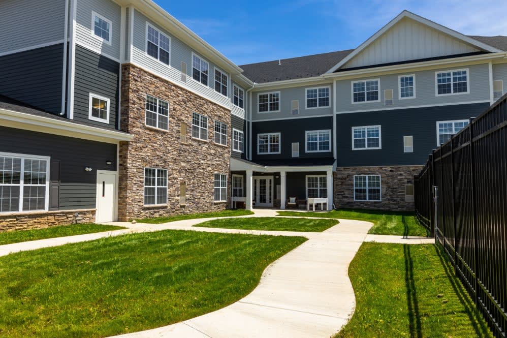 A modern apartment building with a neatly maintained lawn and pathway.