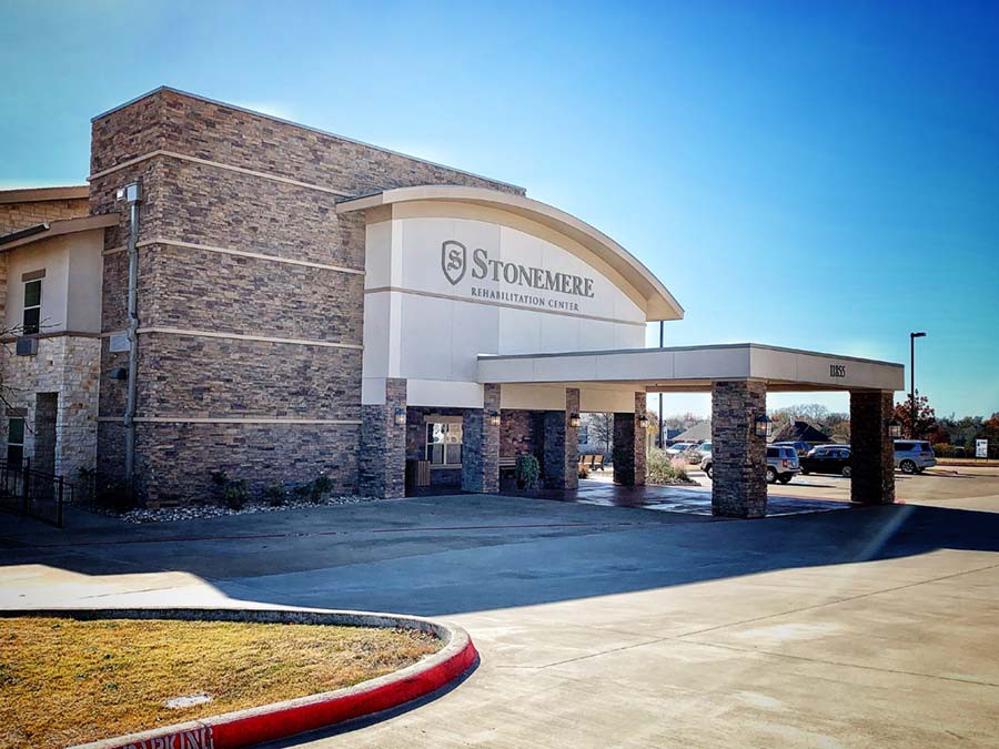 A commercial building with a prominent entrance under a clear blue sky.