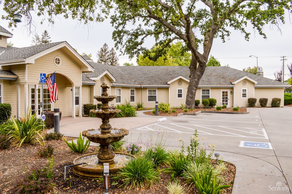 A residential building with a fountain in front and well-maintained landscaping.