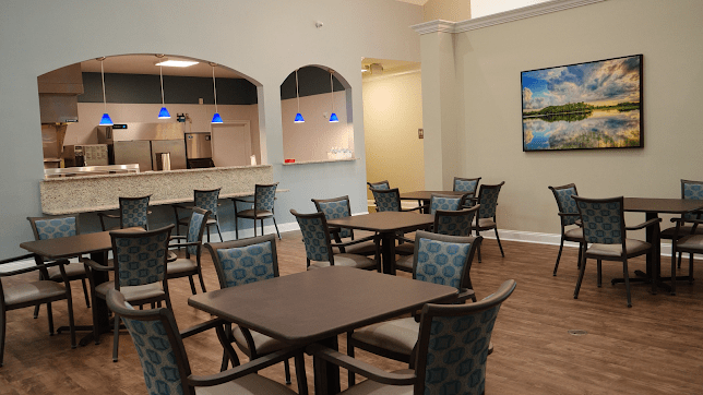 A modern cafe interior with tables and chairs arranged neatly under stylish pendant lights.
