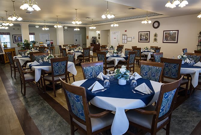 A well-arranged dining room with elegantly set tables featuring blue and white decorations.