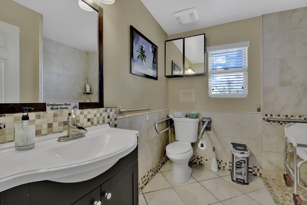 A neatly arranged bathroom with a sink, toilet, and mirror.