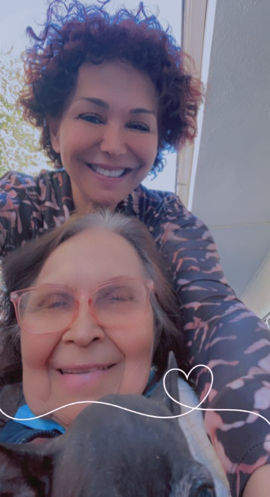 A joyful selfie of two smiling individuals enjoying a moment outdoors.