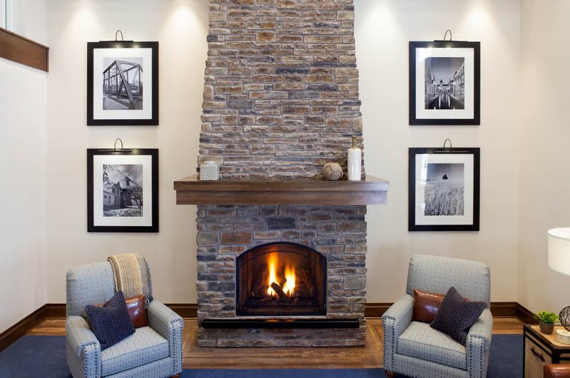 A cozy living room with a brick fireplace and comfortable armchairs.