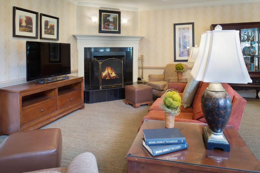 A cozy living room with a fireplace, comfortable seating, and tasteful decor.