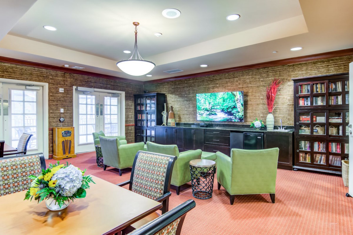 A modern lounge area with comfortable seating and a large television.