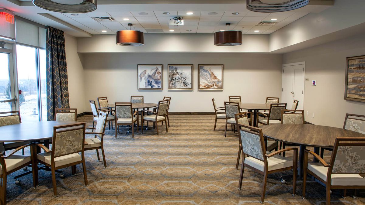 A modern conference room with tables and chairs arranged for a meeting.