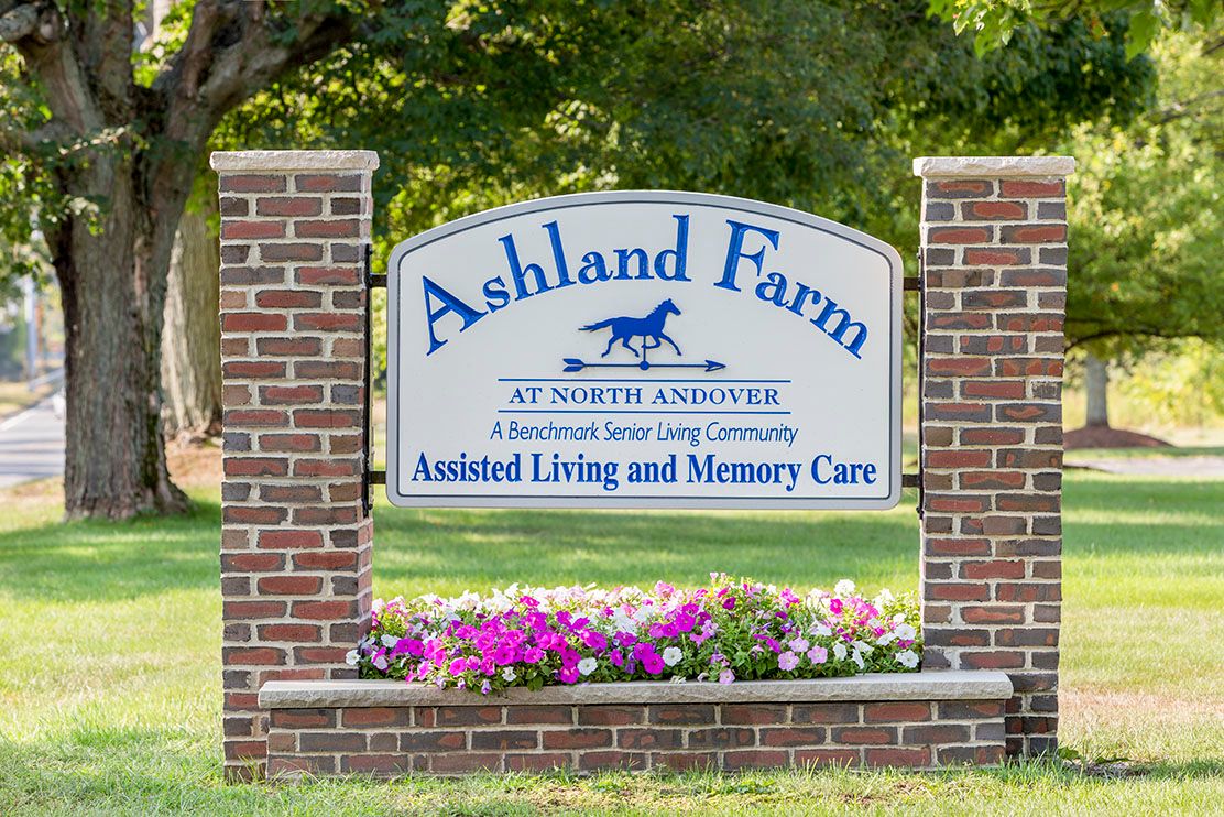 A brick sign for Ashland Farm, promoting assisted living and memory care services.