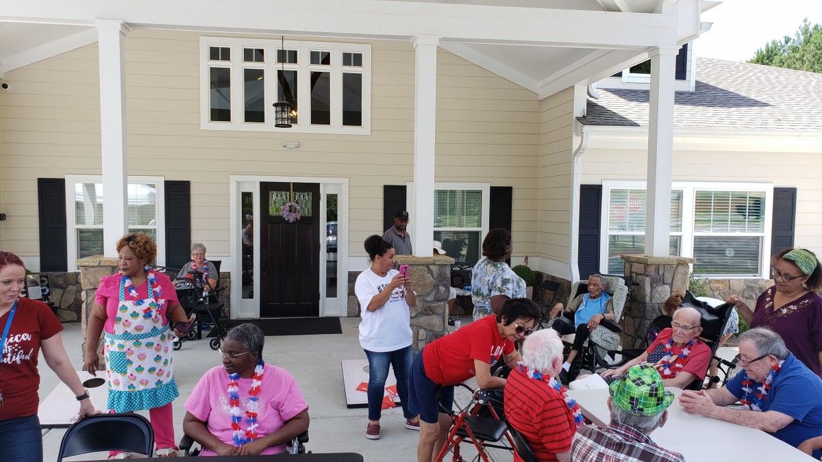 A community gathering with elderly individuals celebrating outdoors.