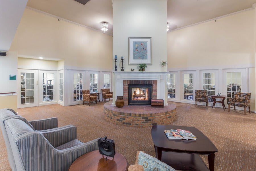 A cozy lounge with a central fireplace and modern seating arrangements.