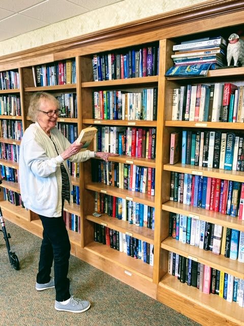 A person organizing books on a library shelf.