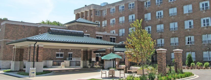A brick healthcare facility with outdoor seating and landscaping.