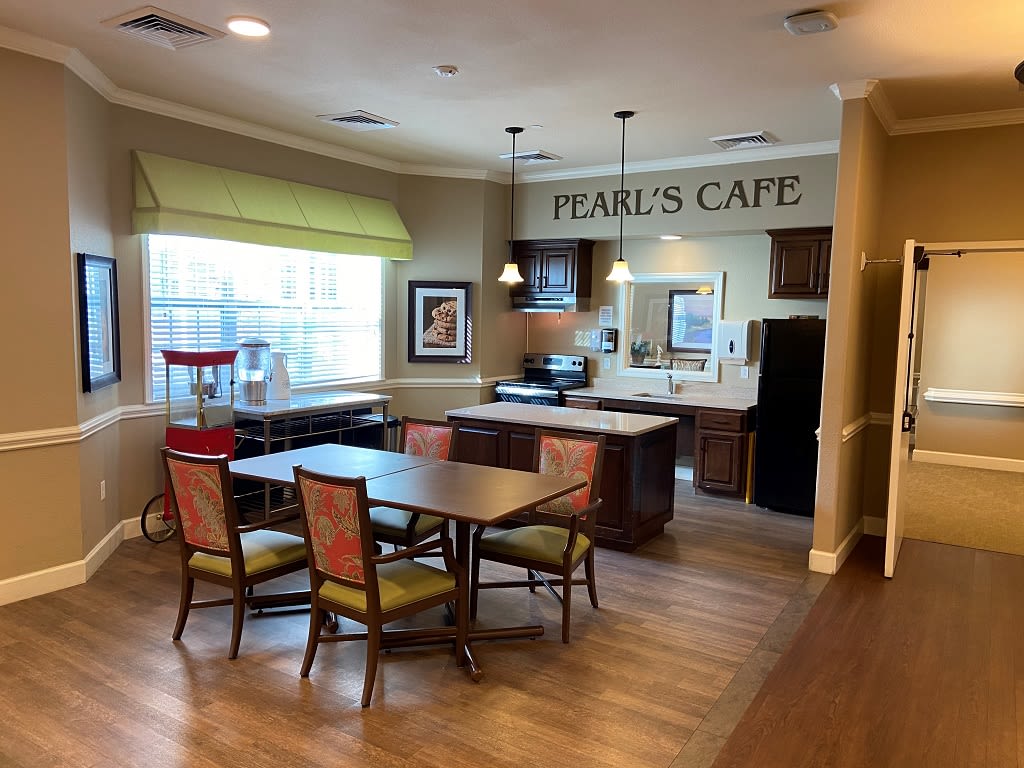 An inviting indoor cafe setting with tables and chairs, known as 'Pearl's Cafe'.