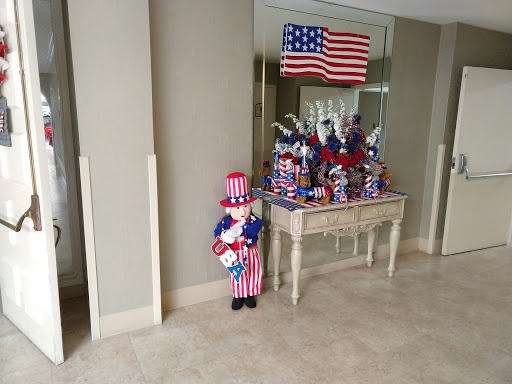 A festive display featuring patriotic decorations, including a figure dressed in red, white, and blue attire alongside an American flag.