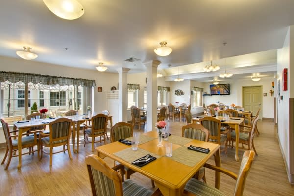 A well-lit dining area with neatly arranged tables and chairs.