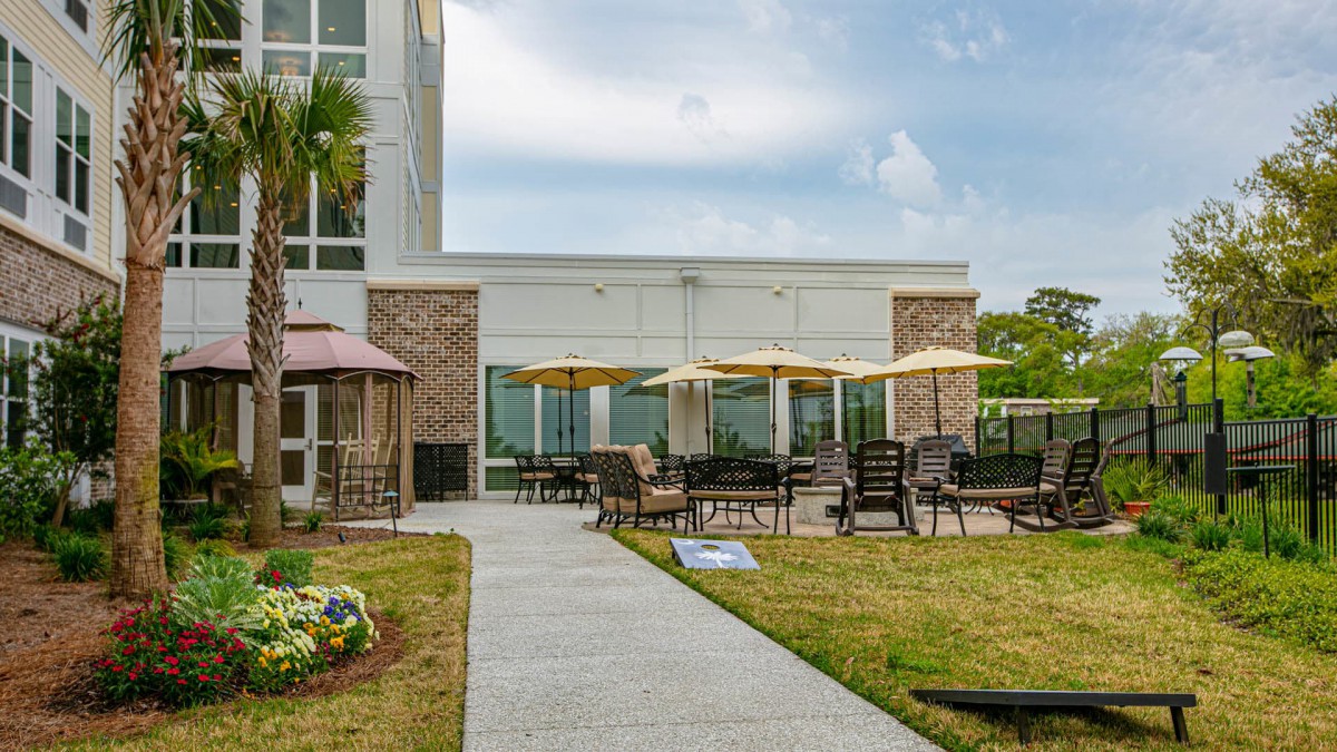 A modern building with an outdoor patio area featuring chairs and umbrellas, ideal for relaxation.