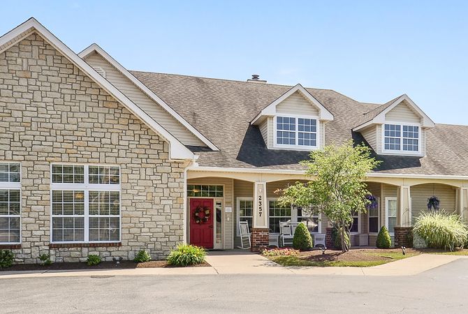 A charming residential house with a stone facade and a well-maintained front yard.