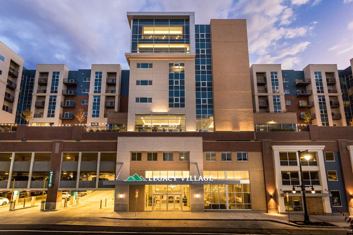 A modern building illuminated at night with glowing lights.
