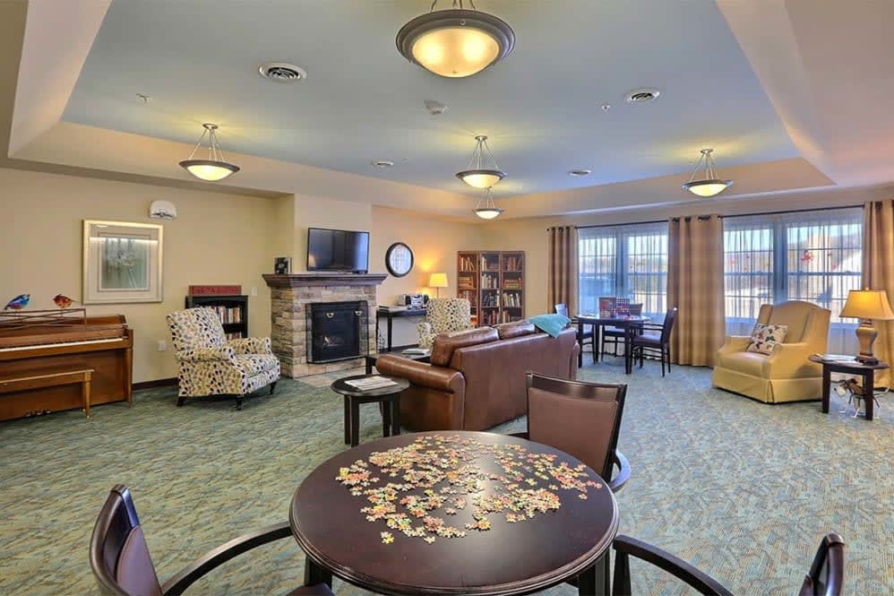 A cozy living room with comfortable seating, a fireplace, and a television.
