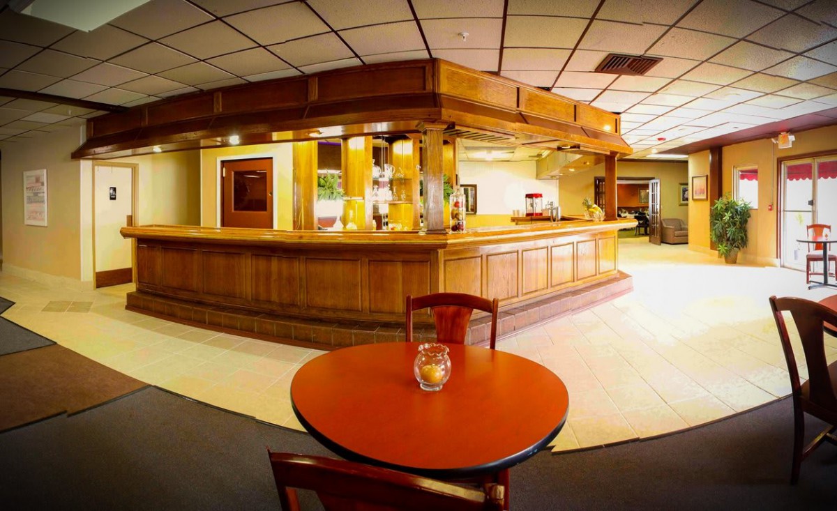 An empty bar area with wooden decor and a small table in the foreground.