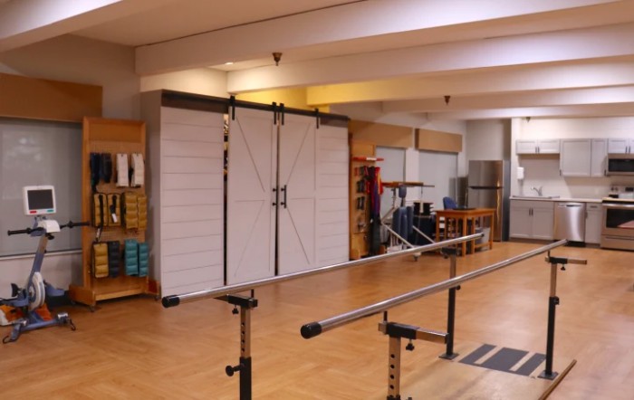 A rehabilitation center equipped with parallel bars and other exercise equipment for physical therapy.