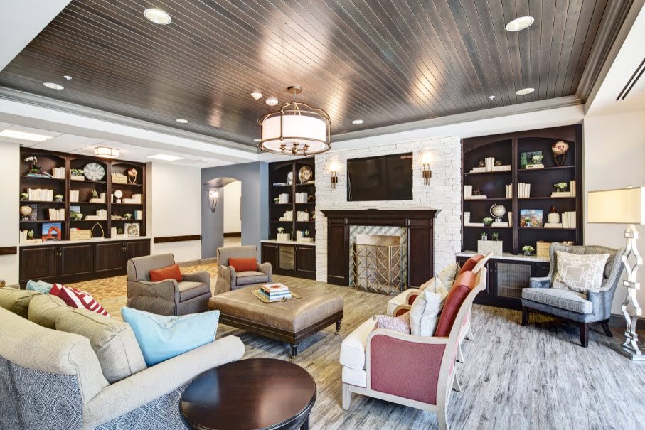 A modern and cozy living room with comfortable seating, a fireplace, and decorative shelves.