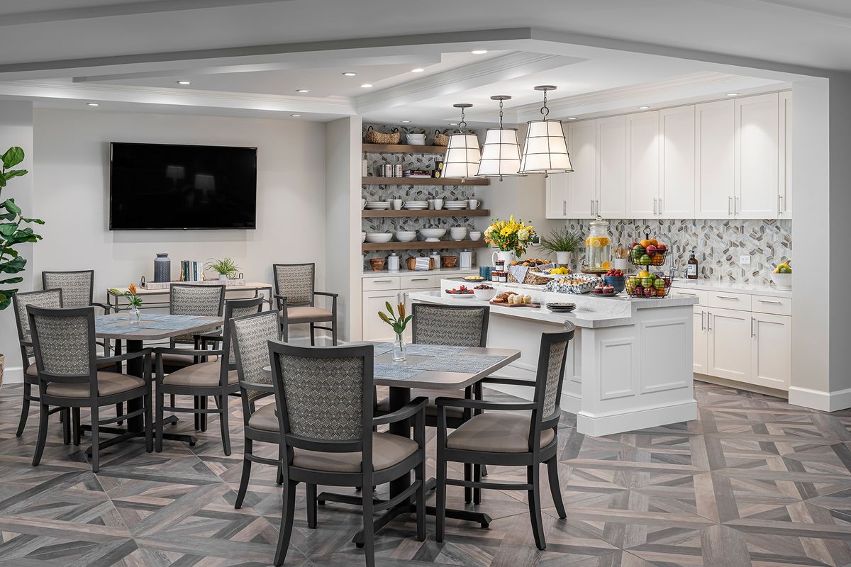 A modern dining area featuring a breakfast buffet with neatly arranged tables and chairs.
