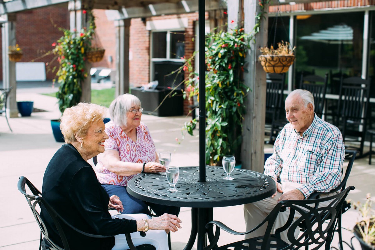 A group of seniors enjoying a casual conversation on a patio.