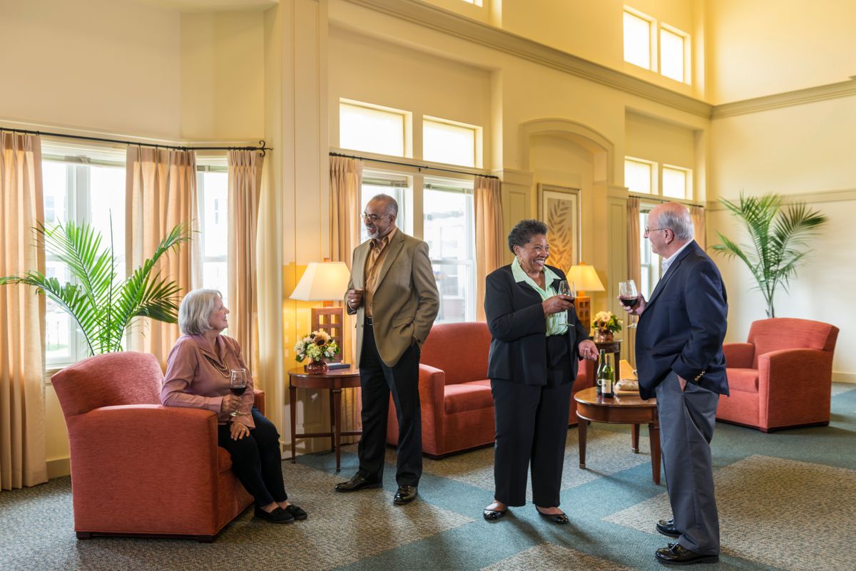 A group of people socializing in a warmly lit living room.