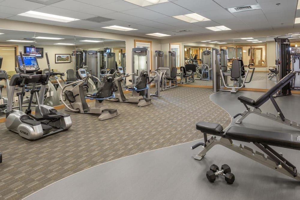 A spacious gym with various workout and cardio equipment.