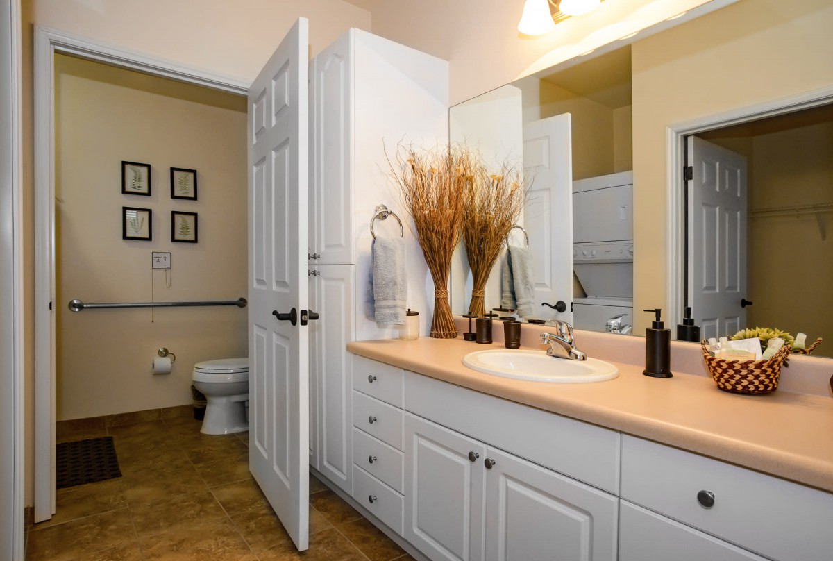 A well-organized bathroom with a large mirror, sink, and decorative elements.