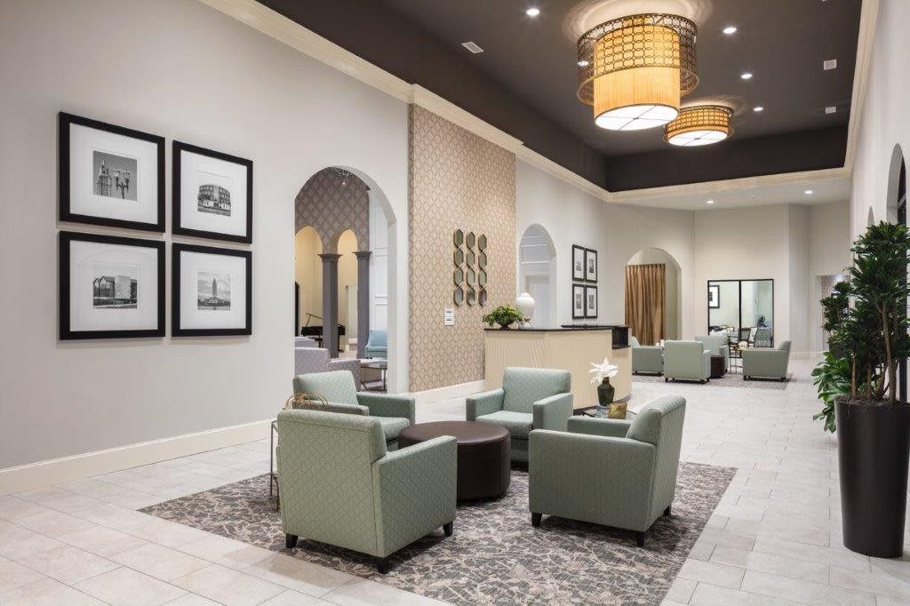A modern lobby with comfortable armchairs, elegant chandeliers, and stylish decor.